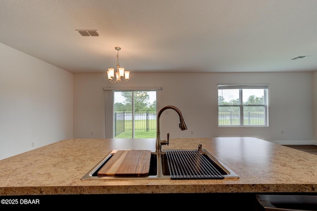569 Armoyan Way, New Smyrna Beach, FL 32168 - kitchen with a sink, open floor plan, a chandelier, hanging light fixtures, and light countertops