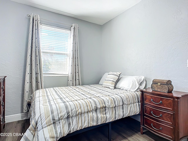 bedroom with multiple windows and hardwood / wood-style flooring