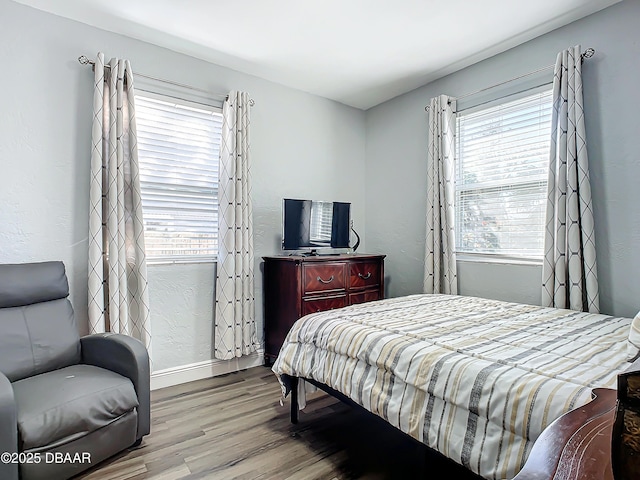 bedroom with light wood-type flooring and multiple windows