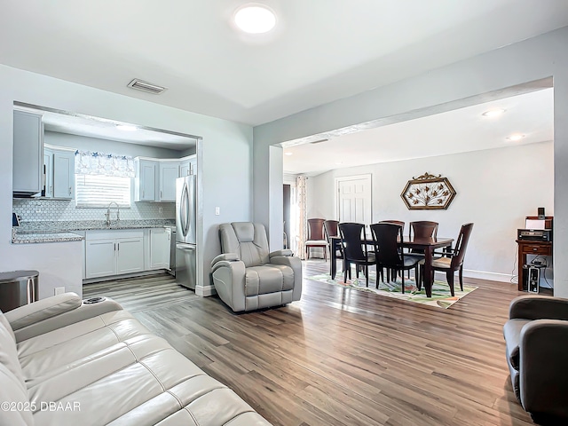 living room featuring sink and light hardwood / wood-style floors