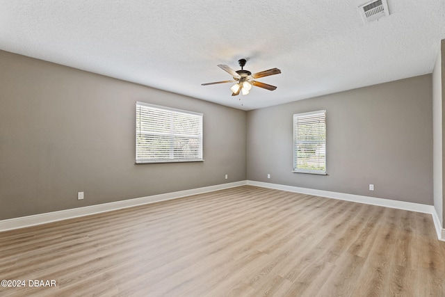 unfurnished room featuring a textured ceiling, ceiling fan, and light hardwood / wood-style flooring