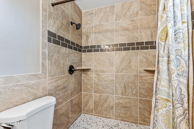 bathroom featuring tile walls, curtained shower, and toilet