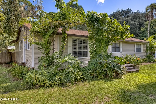 rear view of house featuring a yard