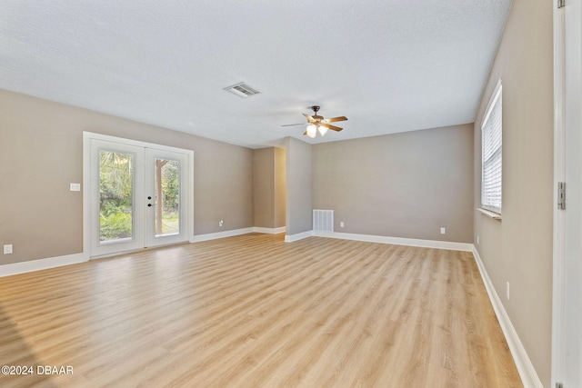 unfurnished room with french doors, light wood-type flooring, a textured ceiling, and ceiling fan