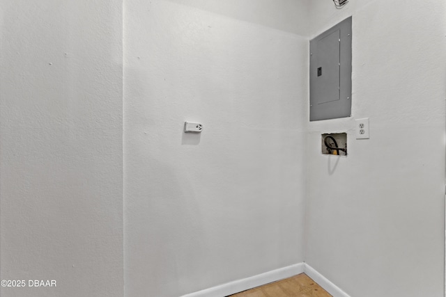 clothes washing area featuring hardwood / wood-style flooring, washer hookup, and electric panel