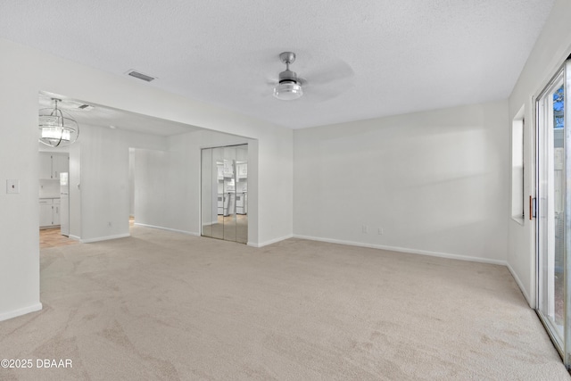 carpeted empty room with ceiling fan and a textured ceiling