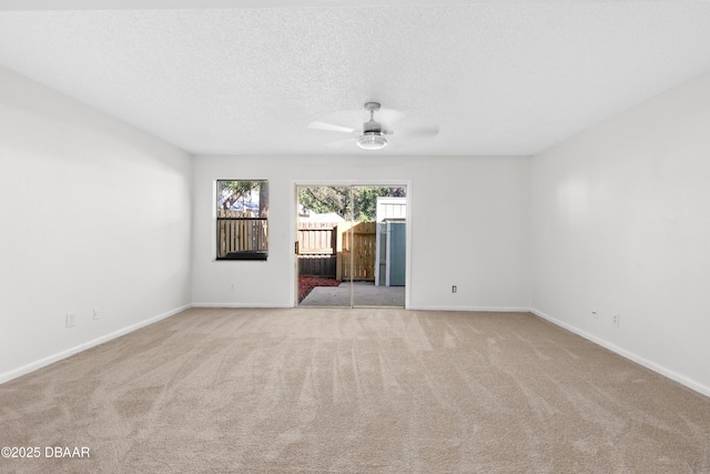 spare room featuring ceiling fan, light colored carpet, and a textured ceiling