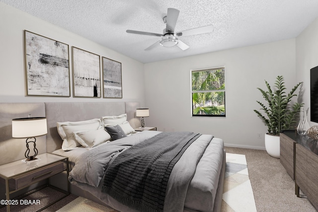 carpeted bedroom featuring ceiling fan and a textured ceiling