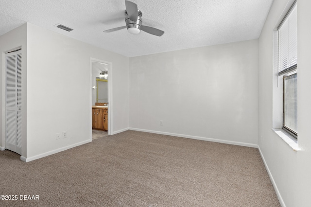 interior space with ceiling fan, light colored carpet, and a textured ceiling