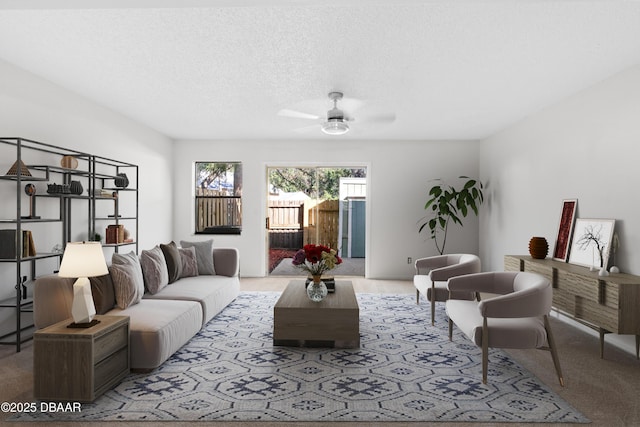 carpeted living room featuring ceiling fan and a textured ceiling