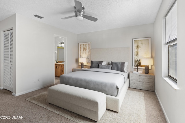 carpeted bedroom with ceiling fan, connected bathroom, a closet, and a textured ceiling