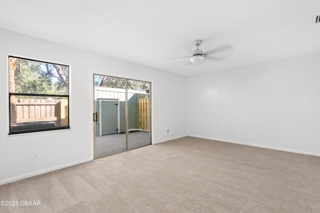 unfurnished room with a textured ceiling, ceiling fan, and carpet flooring