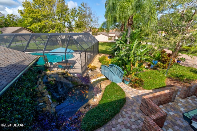 view of pool featuring glass enclosure and a patio area