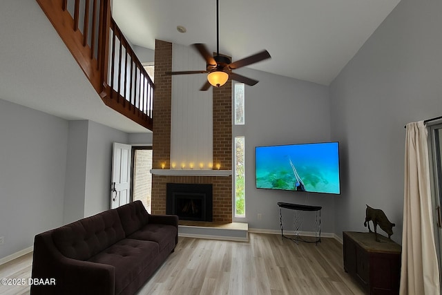 113 Lagoon Ct, New Smyrna Beach, FL 32169 - living area with high vaulted ceiling, light wood-style flooring, a ceiling fan, and a brick fireplace