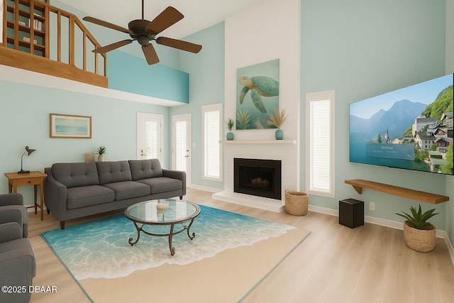 113 Lagoon Ct, New Smyrna Beach, FL 32169 - living area with high vaulted ceiling, a ceiling fan, wood finished floors, and a fireplace with raised hearth
