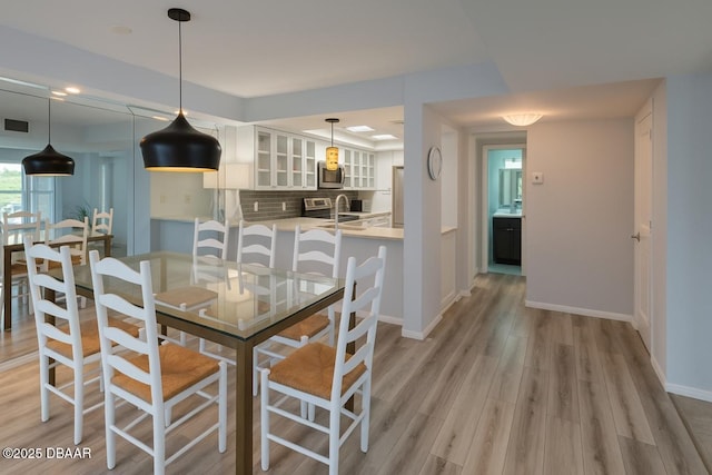 113 Lagoon Ct, New Smyrna Beach, FL 32169 - dining room featuring light wood-type flooring and baseboards