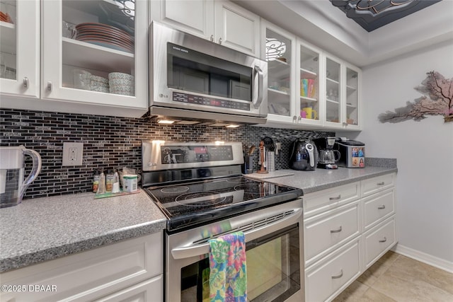 113 Lagoon Ct, New Smyrna Beach, FL 32169 - kitchen featuring appliances with stainless steel finishes, light countertops, backsplash, and white cabinets