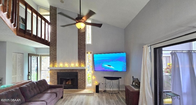 113 Lagoon Ct, New Smyrna Beach, FL 32169 - living area featuring high vaulted ceiling, wood finished floors, a ceiling fan, and a brick fireplace