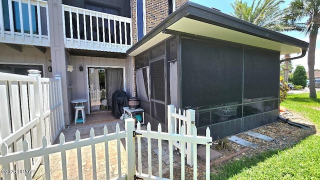 113 Lagoon Ct, New Smyrna Beach, FL 32169 - view of home's exterior with a sunroom, brick siding, and a balcony