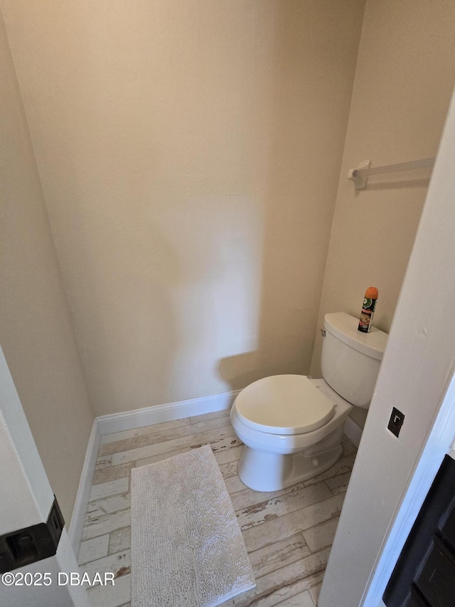 bathroom featuring wood-type flooring and toilet