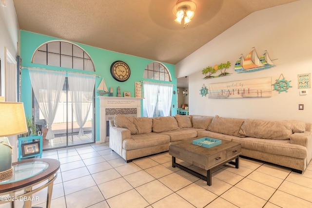 living room featuring light tile patterned floors, lofted ceiling, a textured ceiling, and a ceiling fan