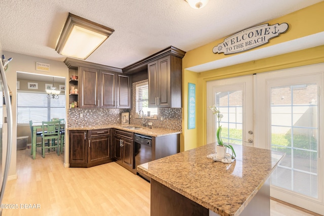 kitchen featuring light wood-style flooring, backsplash, dark brown cabinets, a chandelier, and dishwasher