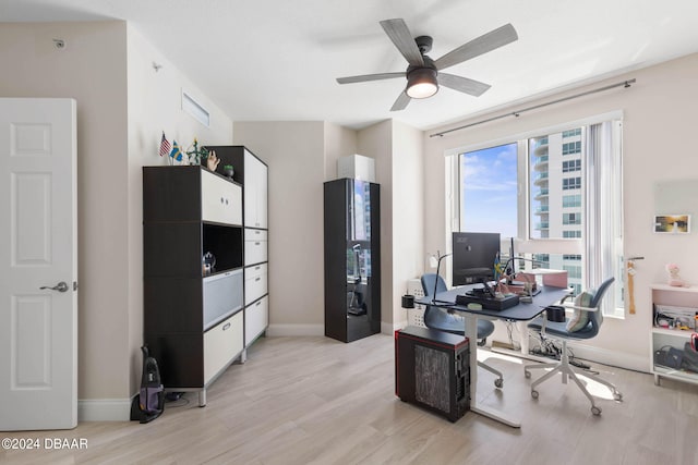 home office featuring ceiling fan and light hardwood / wood-style flooring