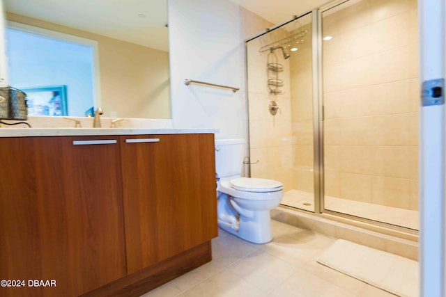 bathroom featuring vanity, tile patterned floors, toilet, and a shower with shower door