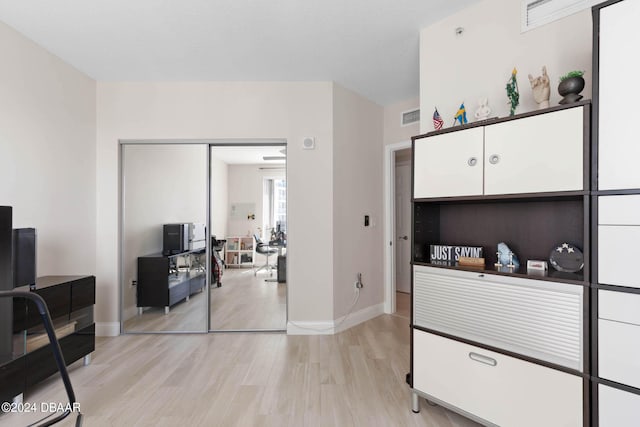 241 Riverside Dr Unit 1401-2, Holly Hill, FL 32117 - bedroom with light wood-style flooring, baseboards, a desk, and a closet