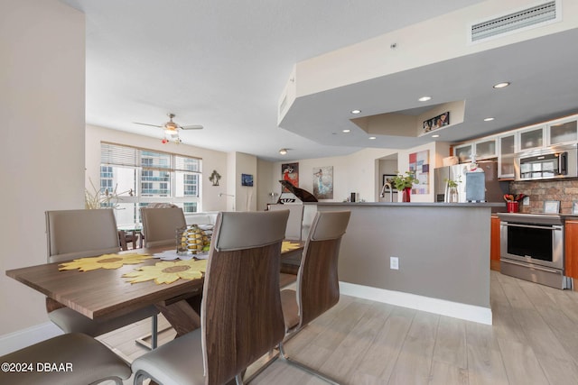 dining area with light hardwood / wood-style flooring and ceiling fan