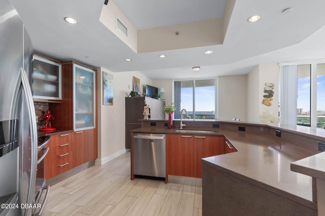 kitchen featuring light wood-type flooring, stainless steel appliances, a healthy amount of sunlight, and sink