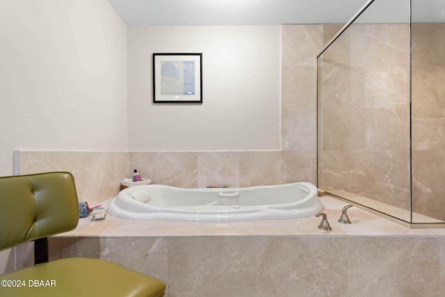 bathroom with a relaxing tiled tub