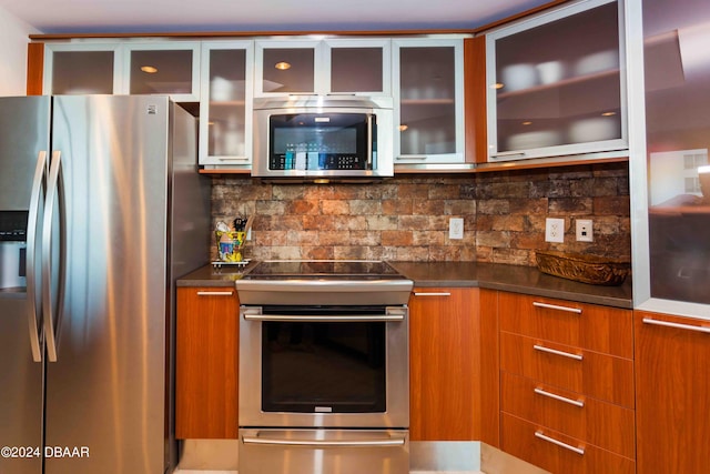 241 Riverside Dr Unit 1401-2, Holly Hill, FL 32117 - kitchen featuring stainless steel appliances, modern cabinets, decorative backsplash, and dark countertops