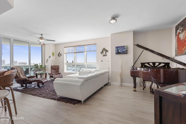 living room with ceiling fan and light hardwood / wood-style floors