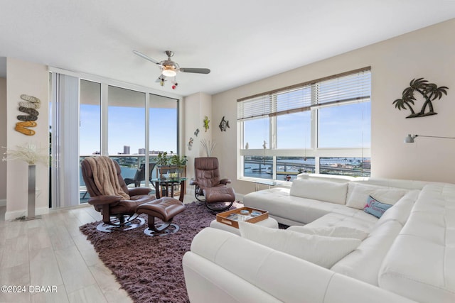 living room featuring a water view, hardwood / wood-style flooring, and ceiling fan