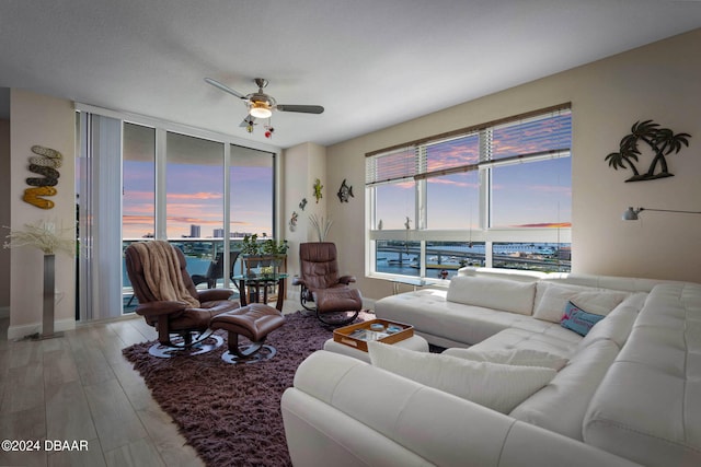 living room with hardwood / wood-style floors, a wealth of natural light, and a water view