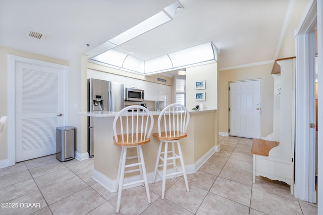 4545 S Atlantic Ave Unit 3704, Ponce Inlet, FL 32127 - kitchen featuring a kitchen breakfast bar, stainless steel appliances, light tile patterned flooring, and visible vents