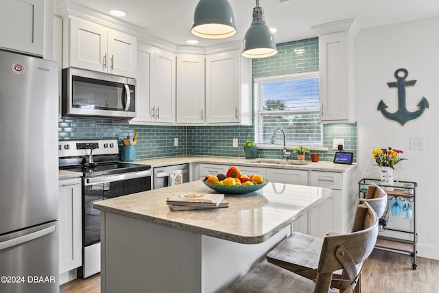1510 Ocean Shore Blvd Unit 4120, Ormond Beach, FL 32176 - kitchen featuring appliances with stainless steel finishes, a sink, a kitchen bar, backsplash, and light wood-style flooring