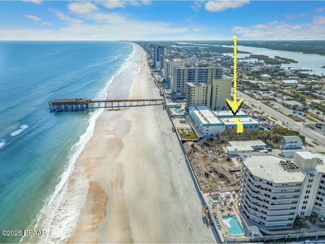 drone / aerial view featuring a beach view and a water view