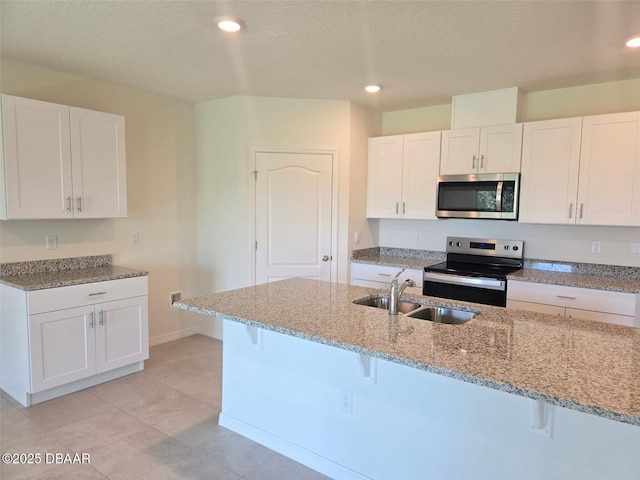 2798 Portadown St, Ormond Beach, FL 32174 - kitchen featuring appliances with stainless steel finishes, light stone counters, a breakfast bar, white cabinetry, and light tile patterned floors