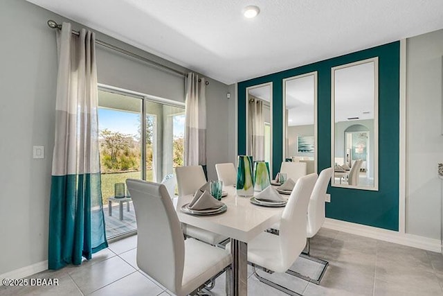 dining room featuring a textured ceiling and light tile patterned floors