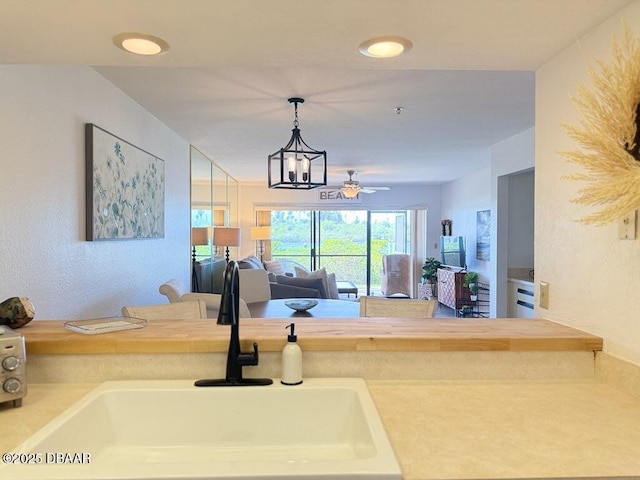 460 Bouchelle Dr Unit 104, New Smyrna Beach, FL 32169 - kitchen featuring a ceiling fan, pendant lighting, a sink, light countertops, and open floor plan