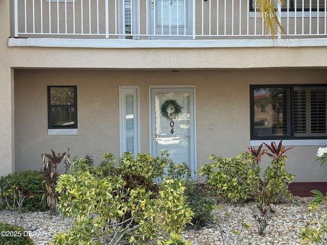 460 Bouchelle Dr Unit 104, New Smyrna Beach, FL 32169 - view of exterior entry featuring a balcony and stucco siding