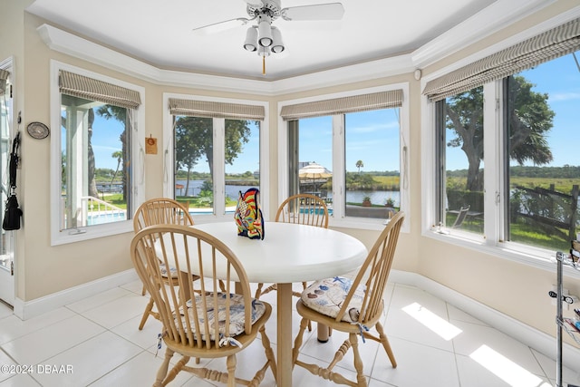 sunroom with a water view and ceiling fan