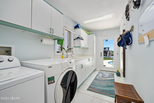 clothes washing area with washer and clothes dryer, cabinets, light tile patterned floors, and sink