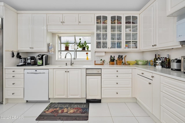 kitchen featuring white cabinetry, sink, white dishwasher, and light tile patterned flooring