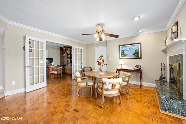 dining area featuring a fireplace, light parquet flooring, french doors, and ornamental molding