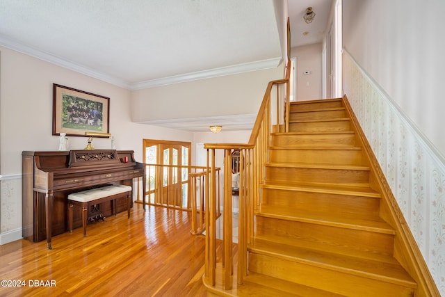 stairway featuring hardwood / wood-style flooring and ornamental molding