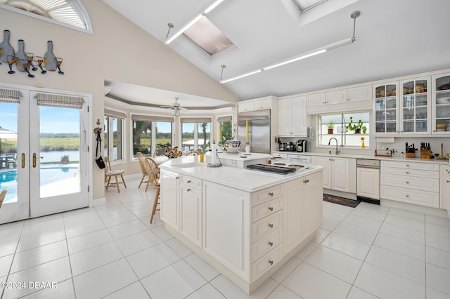 kitchen featuring appliances with stainless steel finishes, french doors, a kitchen island, ceiling fan, and white cabinetry