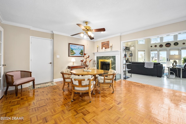 dining space with a high end fireplace, light parquet floors, a textured ceiling, and ceiling fan